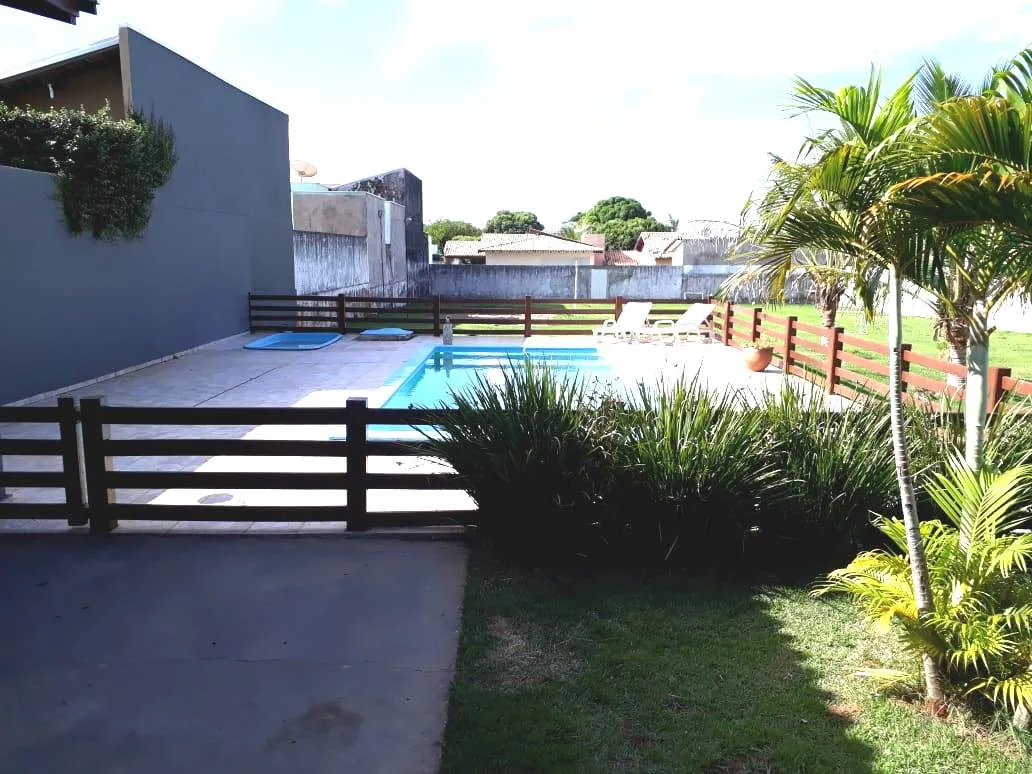 Piscina do Espaço ToaToa vista do portão da cerca, com piscina infantil, espreguiçadeiras e coqueiros