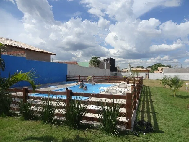 Família na piscina do Espaço ToaToa, com cerca de madeira e espreguiçadeiras