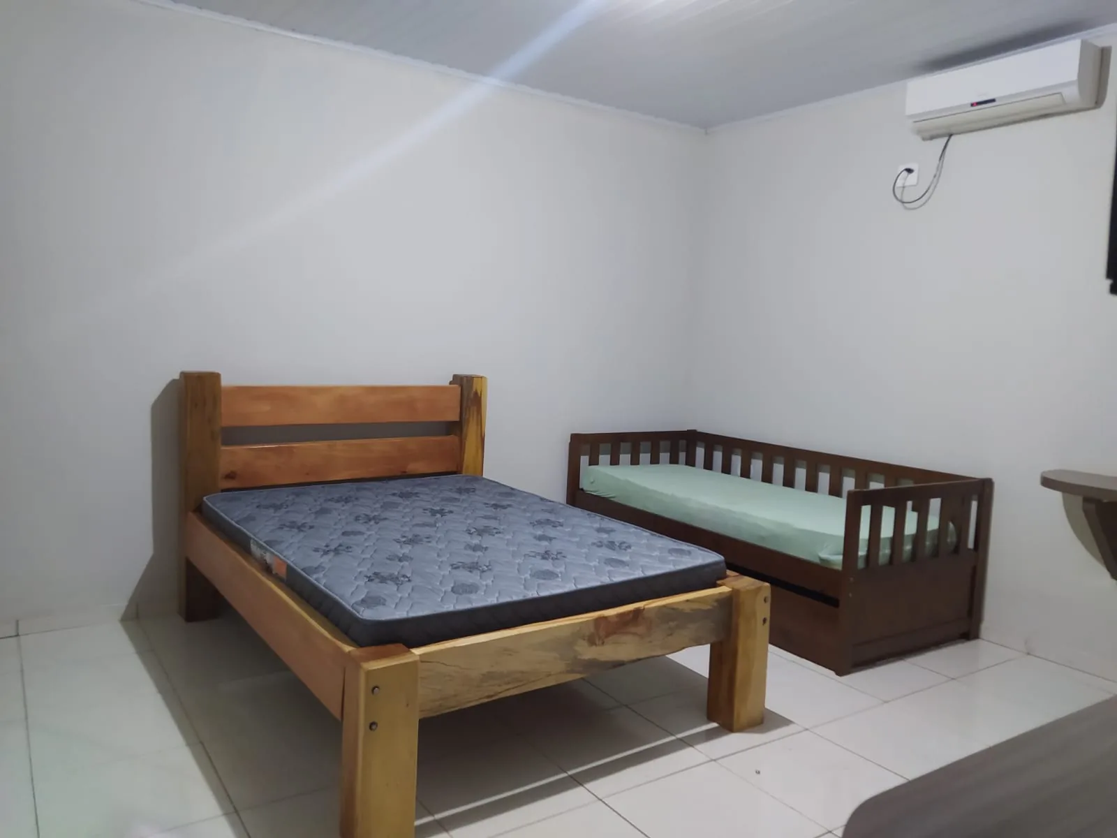 Suíte do Espaço ToaToa com cama de casal de madeira, cama extra e ar-condicionado